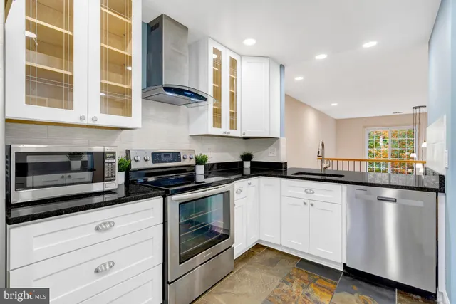 a kitchen with stainless steel appliances granite countertop a stove and a sink