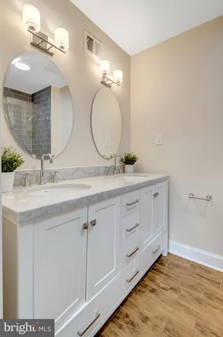 a bathroom with a double vanity sink and a mirror