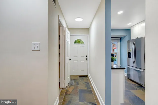 a view of a hallway with wooden cabinets
