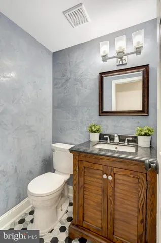 a bathroom with a granite countertop toilet sink and mirror