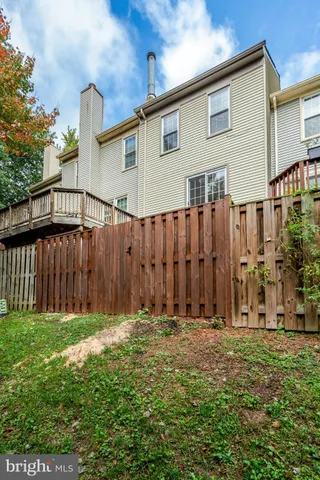 a view of backyard with potted plants and wooden fence