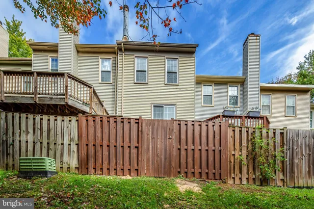 a view of a house with a small yard and wooden fence