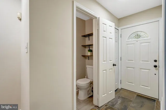 a bathroom with a granite countertop sink a toilet and shower