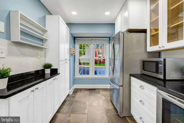 a kitchen with stainless steel appliances a refrigerator and a stove top oven