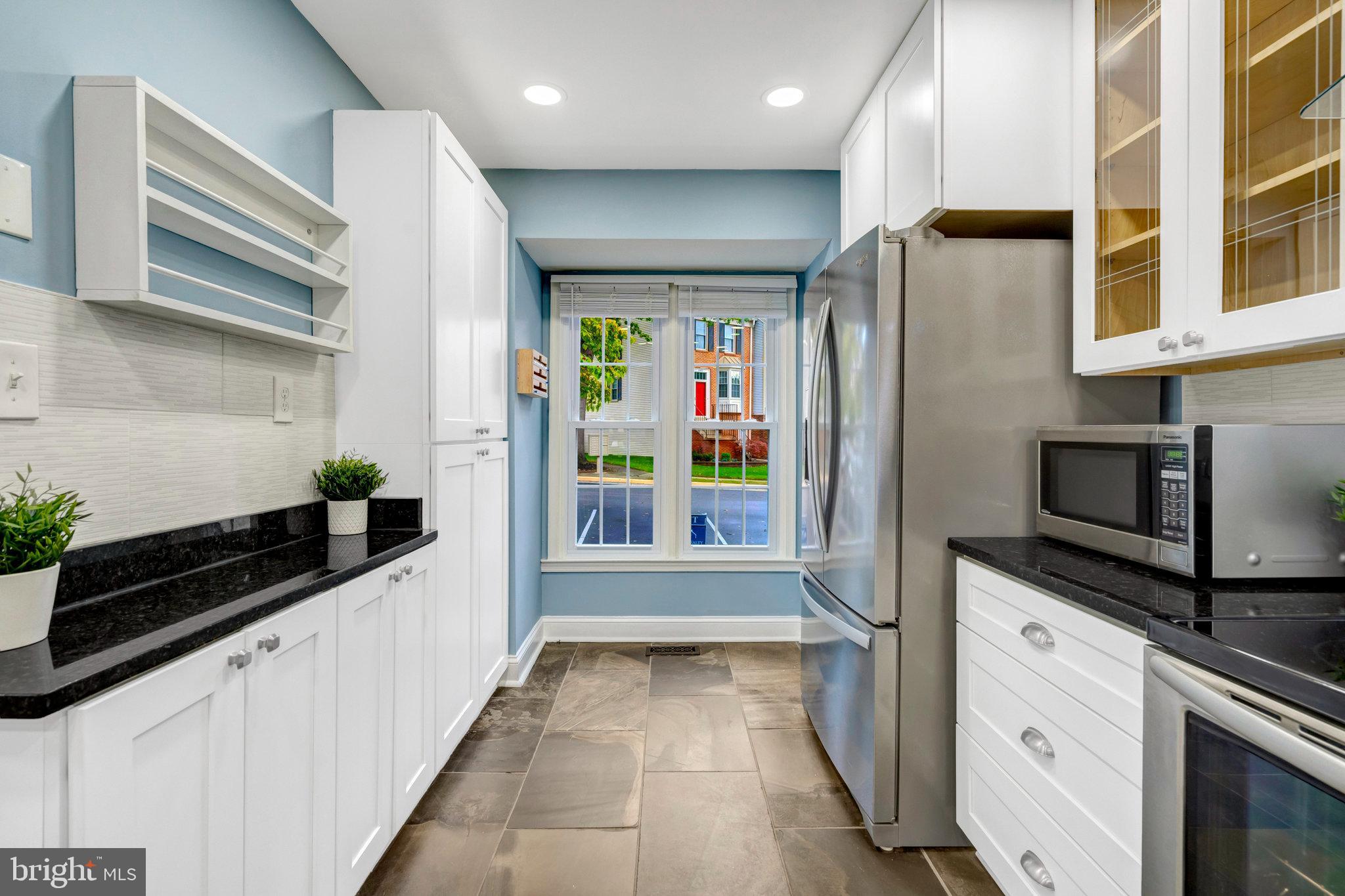 8482 Springfield Oaks Drive Springfield, VA 22153 - Photo 9 of 48 a kitchen with stainless steel appliances a refrigerator and a stove top oven