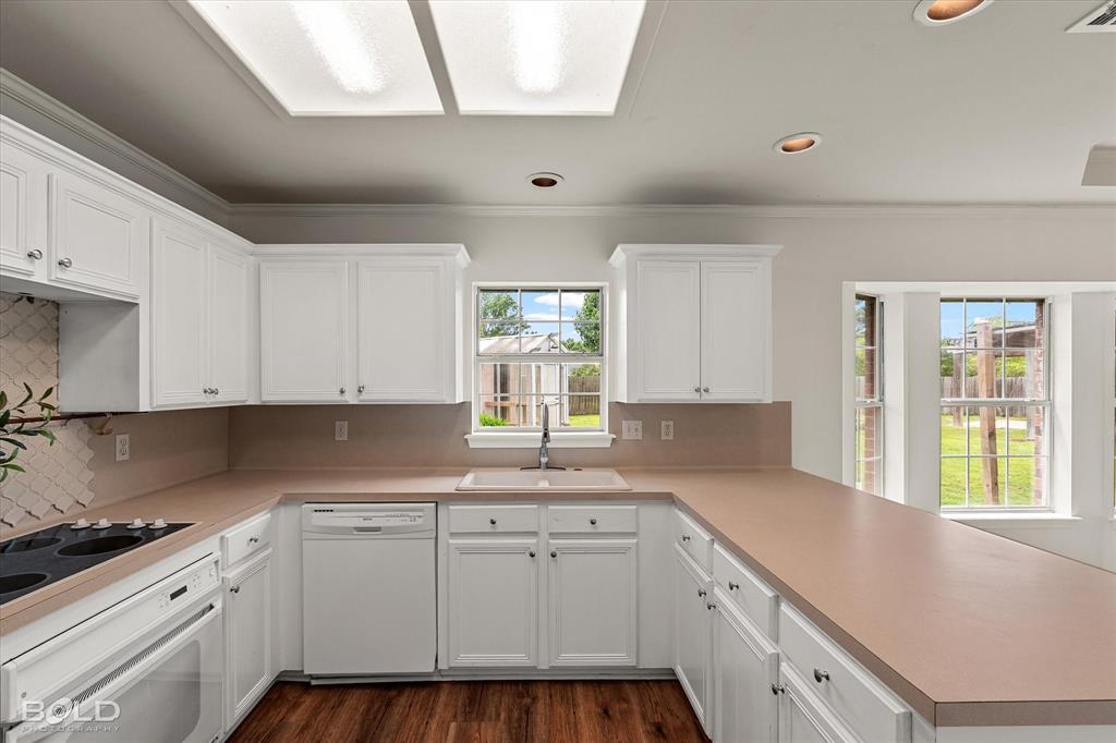 1962 Palmetto Road Benton, LA 71006 - Photo 13 of 40 The kitchen offers white cabinetry, countertops, and a sink with a window overlooking the outdoors