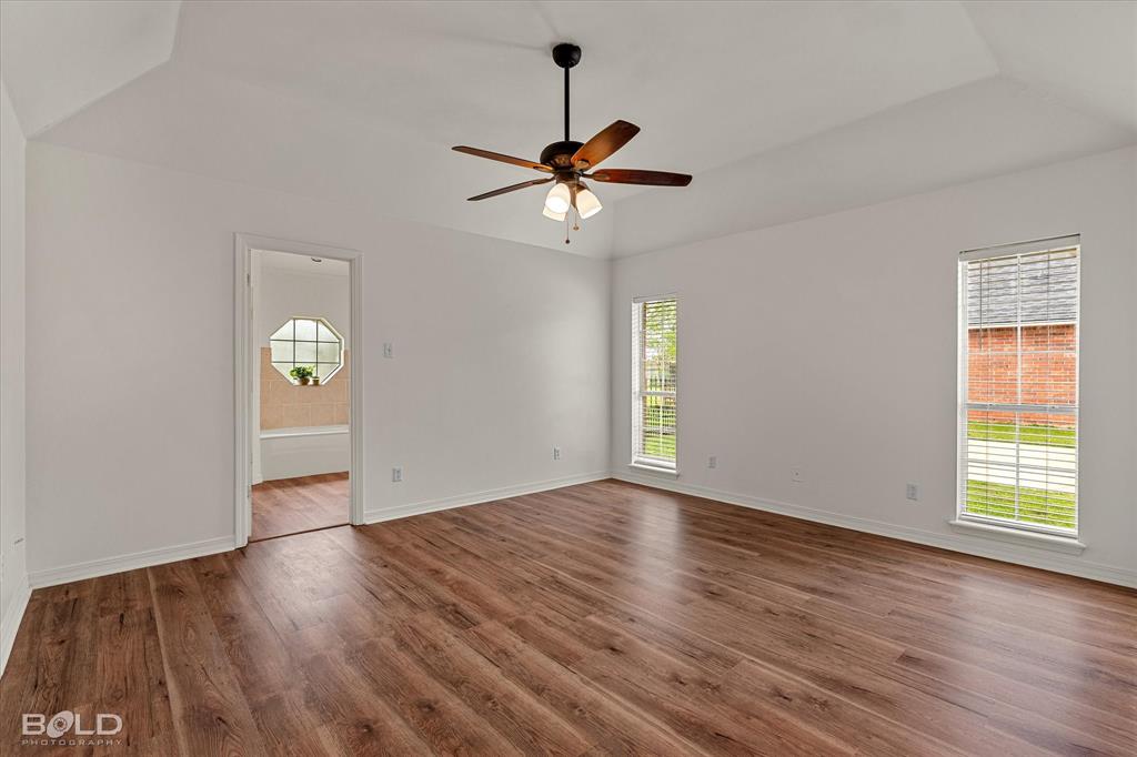 1962 Palmetto Road Benton, LA 71006 - Photo 15 of 40 This spacious room features wood-look flooring, a ceiling fan with integrated lighting, and two windows with blinds