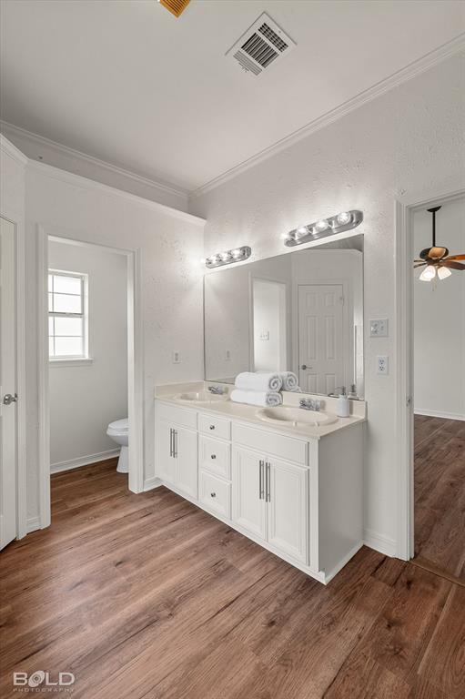 1962 Palmetto Road Benton, LA 71006 - Photo 16 of 40 Bathroom featuring a double vanity with white cabinetry, light-colored countertops, and two mirrors illuminated by sconce lighting