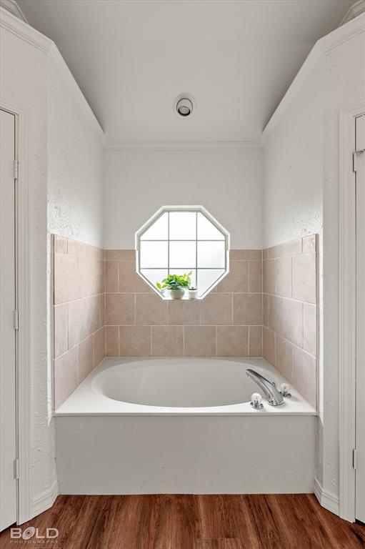 1962 Palmetto Road Benton, LA 71006 - Photo 17 of 40 Bathroom featuring a built-in tub with chrome fixtures, an octagonal window, and wall tiling