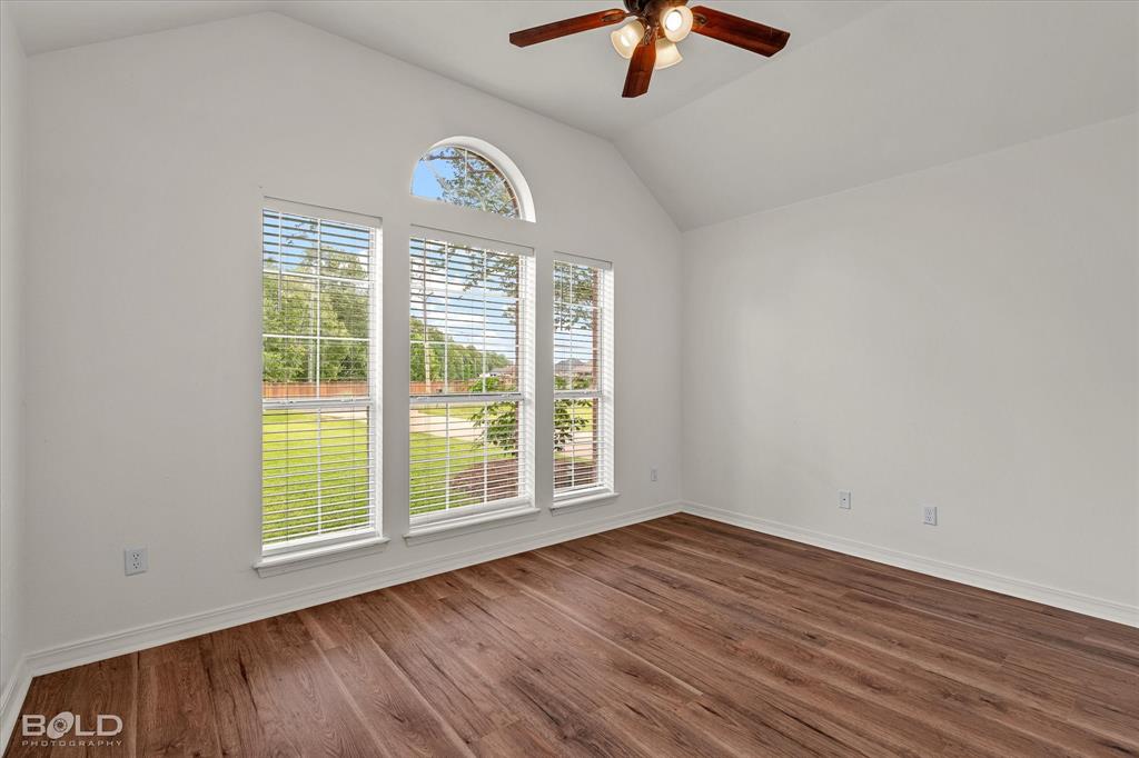 1962 Palmetto Road Benton, LA 71006 - Photo 20 of 40 This room features vaulted ceilings, rich wood-style flooring, and an abundance of natural light from the three large windows, including a prominent arched window