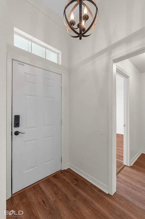 1962 Palmetto Road Benton, LA 71006 - Photo 2 of 40 Entryway featuring a white paneled door with a transom window, wood-look flooring, and a decorative spherical light fixture