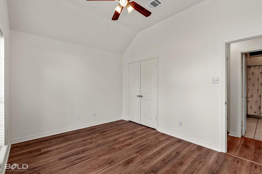 1962 Palmetto Road Benton, LA 71006 - Photo 21 of 40 This bright room features a vaulted ceiling, wood-look flooring, and a ceiling fan with integrated lighting