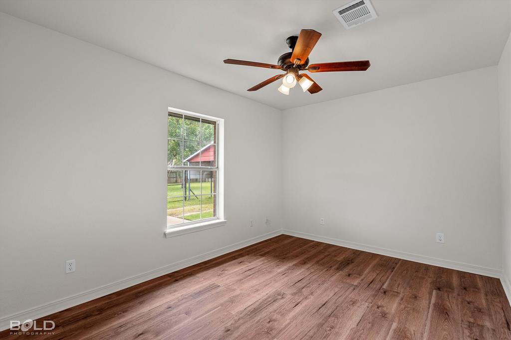 1962 Palmetto Road Benton, LA 71006 - Photo 23 of 40 This room features durable wood-look flooring, a window providing natural light, and a ceiling fan with integrated lighting