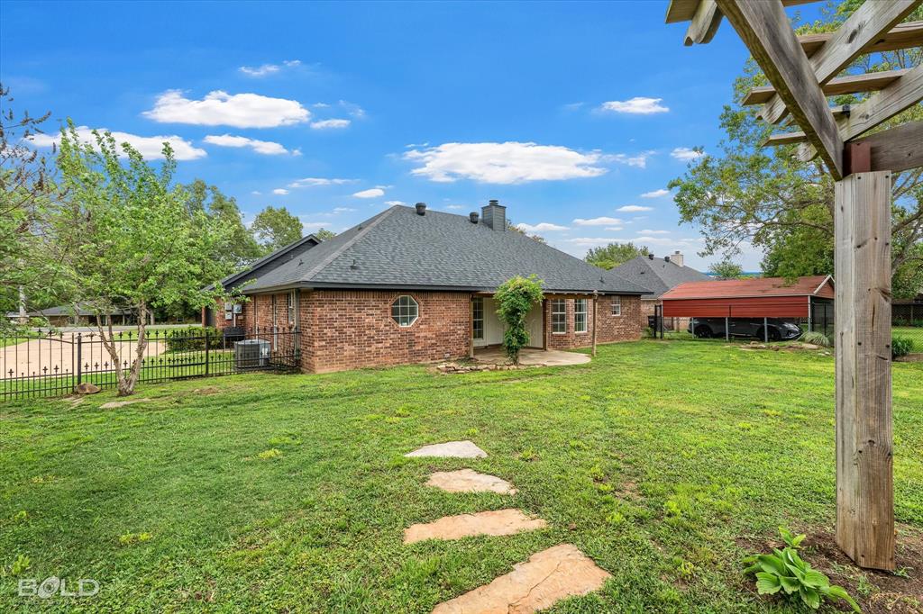 1962 Palmetto Road Benton, LA 71006 - Photo 29 of 40 The property features a brick exterior, a dark shingled roof, and a circular window