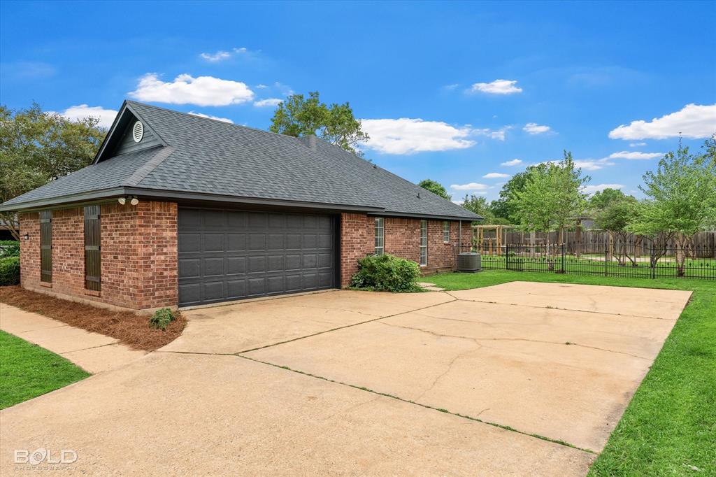 1962 Palmetto Road Benton, LA 71006 - Photo 33 of 40 The property features a brick exterior, a dark grey roof, and a spacious concrete driveway