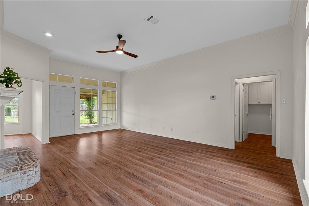 1962 Palmetto Road Benton, LA 71006 - Photo 5 of 40 Spacious living area featuring hardwood flooring, a ceiling fan, and large windows providing natural light