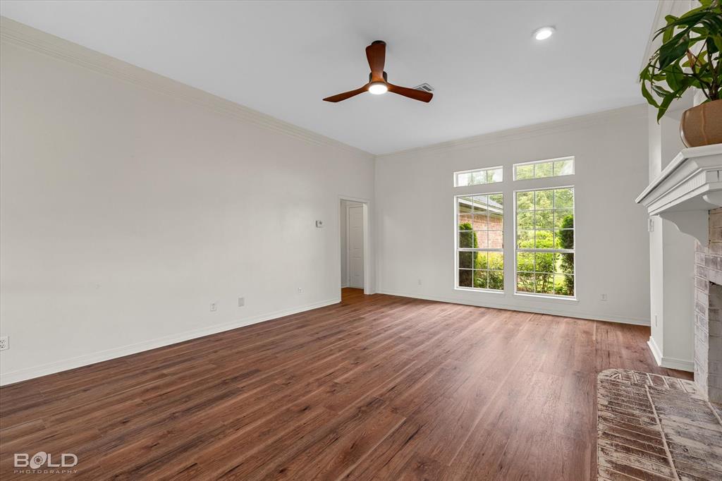 1962 Palmetto Road Benton, LA 71006 - Photo 6 of 40 The living area features wood flooring, a ceiling fan, and large windows providing views of the exterior