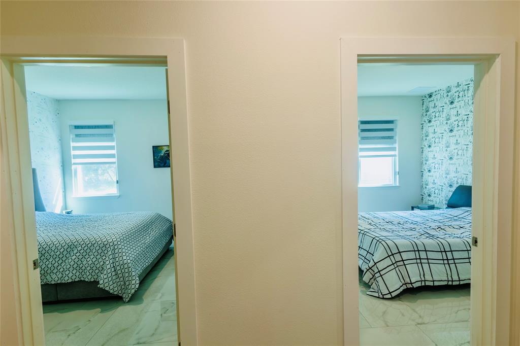 2149 Southwest Susset Lane Port St. Lucie, FL 34953 - Photo 17 of 47 a bedroom with a bed and a mirror