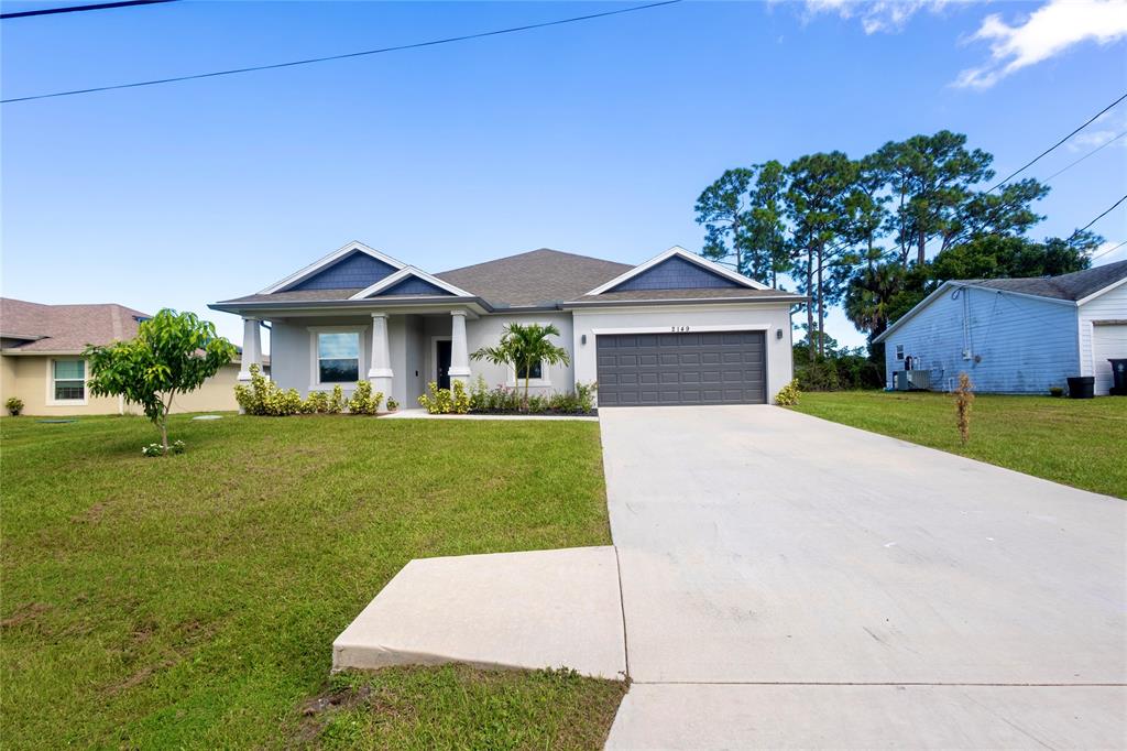 2149 Southwest Susset Lane Port St. Lucie, FL 34953 - Photo 2 of 47 a front view of a house with a yard and trees
