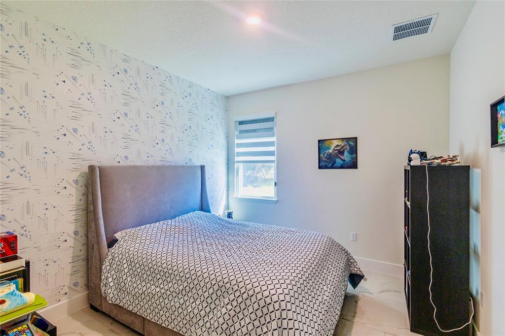2149 Southwest Susset Lane Port St. Lucie, FL 34953 - Photo 21 of 47 a bedroom with a bed and a wall painting