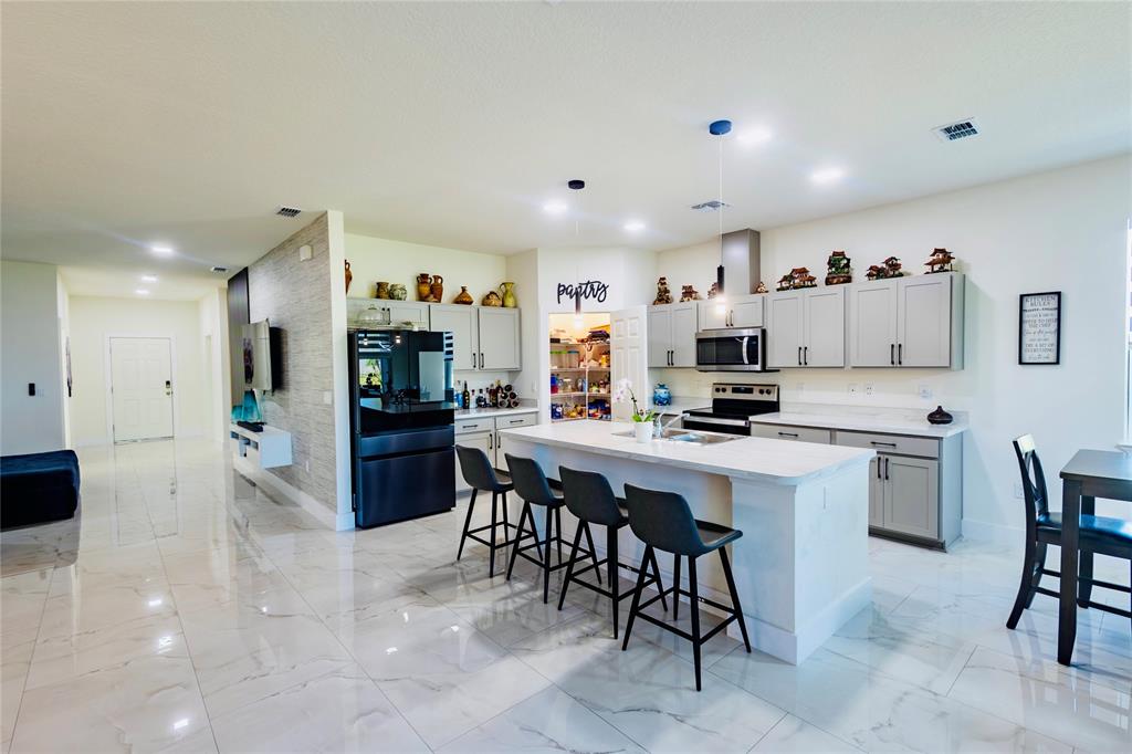 2149 Southwest Susset Lane Port St. Lucie, FL 34953 - Photo 25 of 47 a kitchen with a sink and chairs