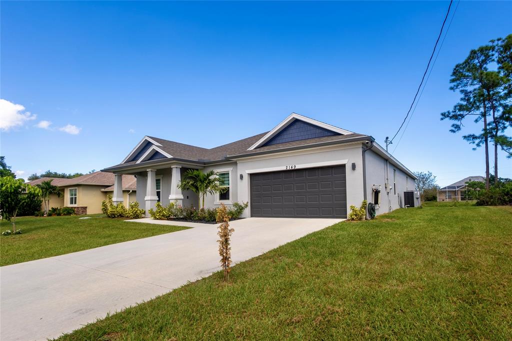 2149 Southwest Susset Lane Port St. Lucie, FL 34953 - Photo 3 of 47 a front view of a house with a yard and garage