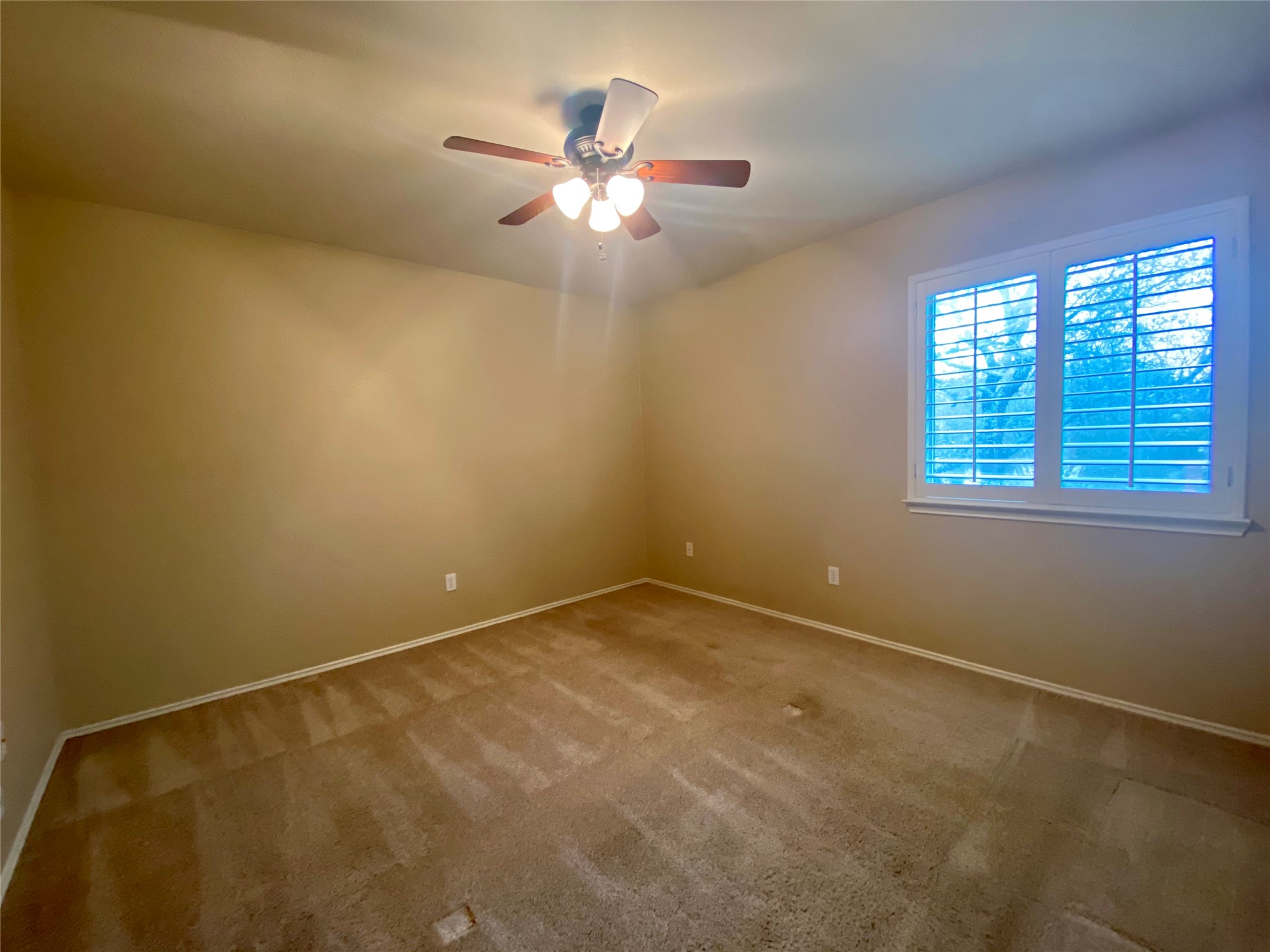 4615 Tello Path Austin, TX 78749 - Photo 22 of 29 A comfortable bedroom with soft carpeting and a window featuring elegant plantation shutters.