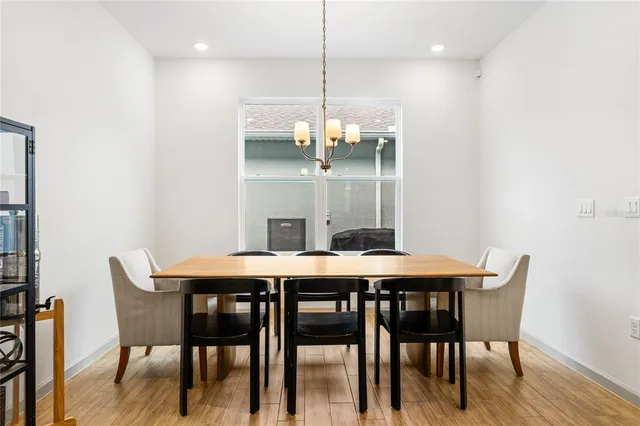 a dining room with furniture a chandelier and wooden floor