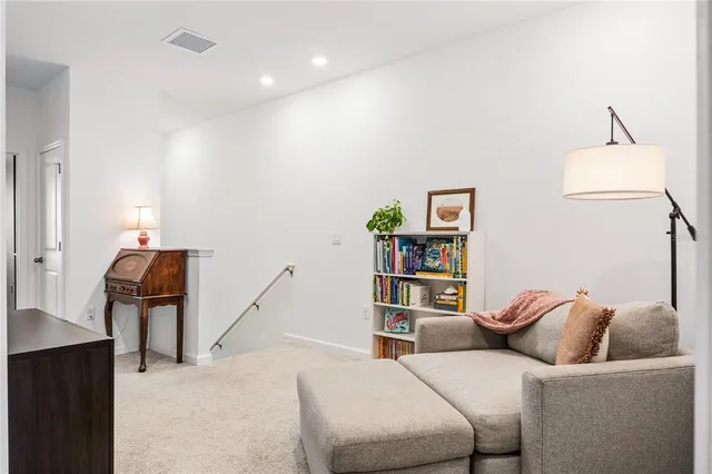 a living room with furniture and a book shelf
