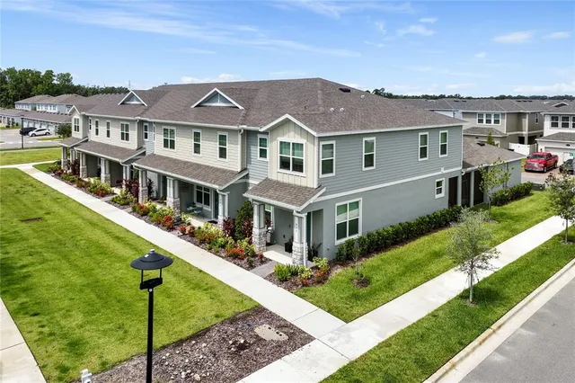 a front view of residential houses with yard and green space