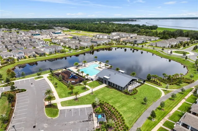 an aerial view of a house with a garden and lake view