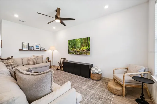 a living room with furniture and a ceiling fan