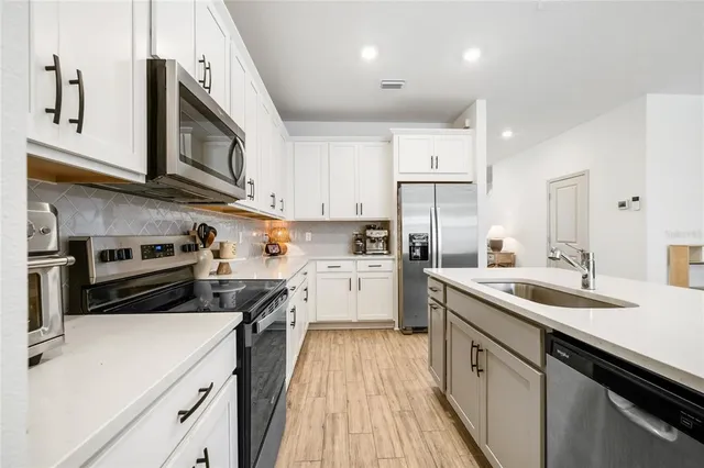 a kitchen with stainless steel appliances granite countertop lots of counter space a sink and cabinets