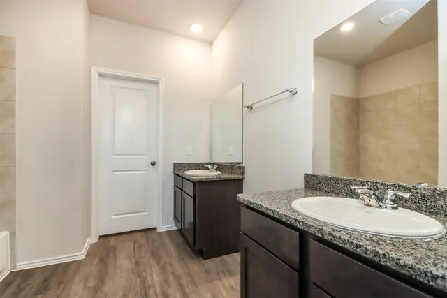 a bathroom with a granite countertop sink toilet and a mirror