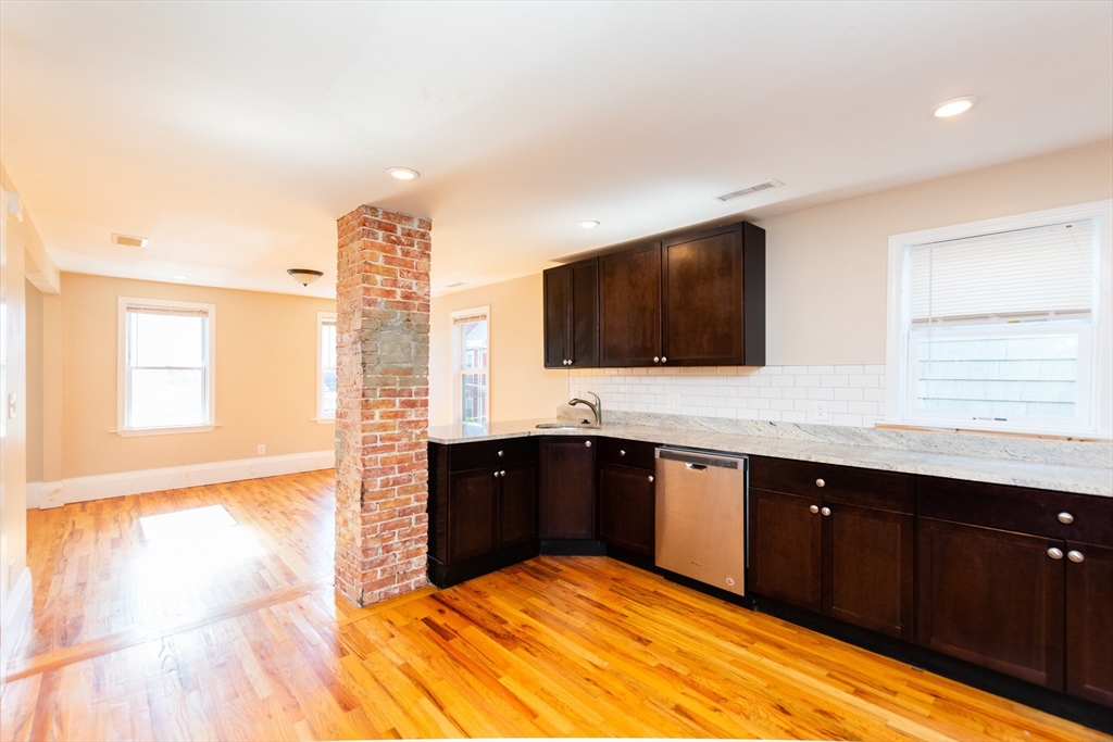 a large kitchen with granite countertop a sink and a stove top oven