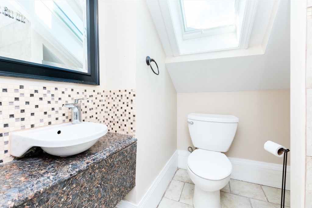 27 Shannon Street, Unit 2L Boston, MA 02135 - Photo 12 of 22 a bathroom with a granite countertop toilet a sink and a mirror