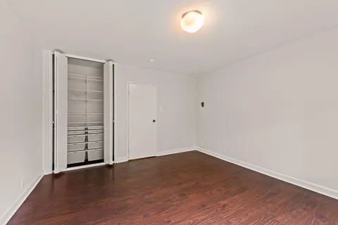 an empty room with wooden floor and window