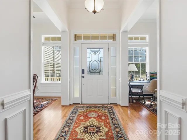 a view of a bedroom with wooden floor and windows