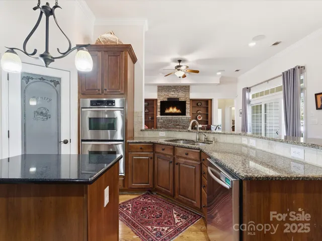 a kitchen with stainless steel appliances granite countertop a stove a sink and a refrigerator