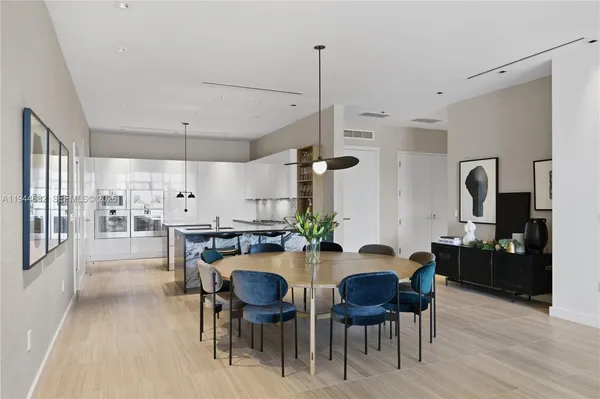 a kitchen with stainless steel appliances kitchen island a table and chairs in it