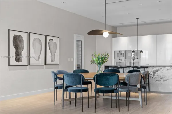 a kitchen with granite countertop a table chairs stove and cabinets