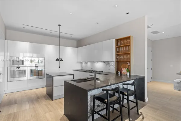 a kitchen with granite countertop a sink and a stove top oven
