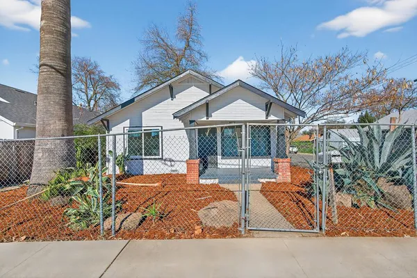 a view of house with backyard and sitting area