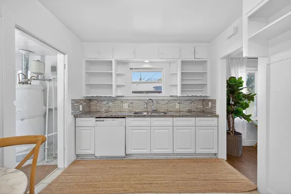 a bathroom with a granite countertop sink a toilet and shower