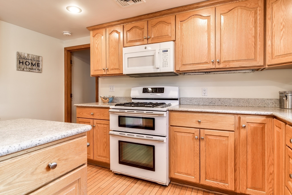 8 Edwards Road Natick, MA 01760 - Photo 8 of 29 a kitchen with granite countertop white cabinets and stainless steel appliances