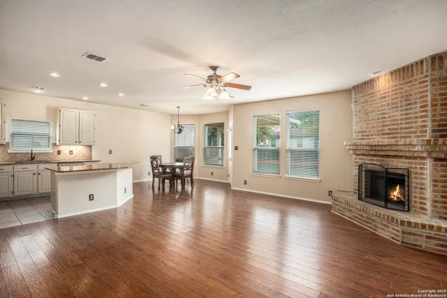 a open kitchen with white cabinets and wooden floor