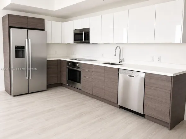 a kitchen with stainless steel appliances granite countertop a refrigerator sink and microwave