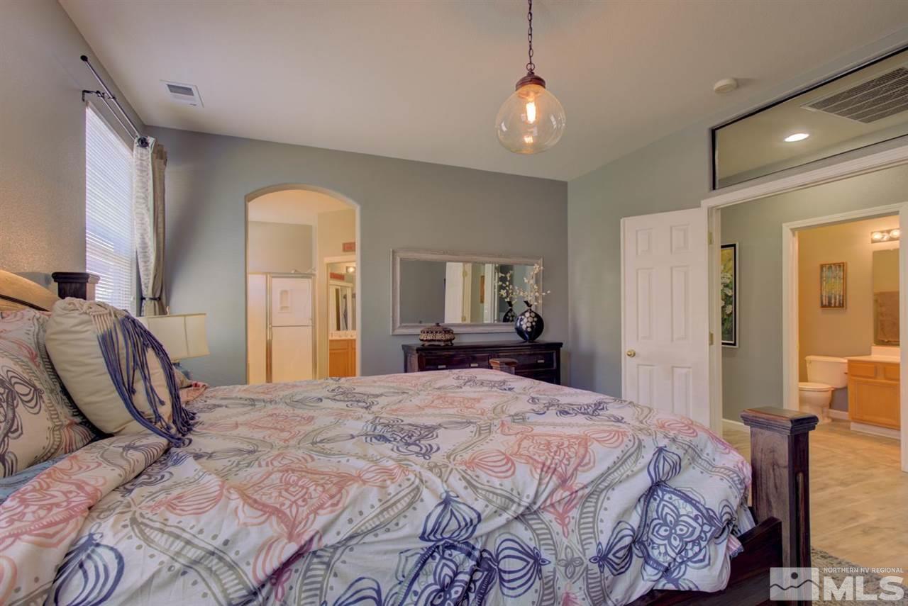 10482 Gold Trail Drive Reno, NV 89521 - Photo 14 of 40 a bedroom with a bed and a chandelier
