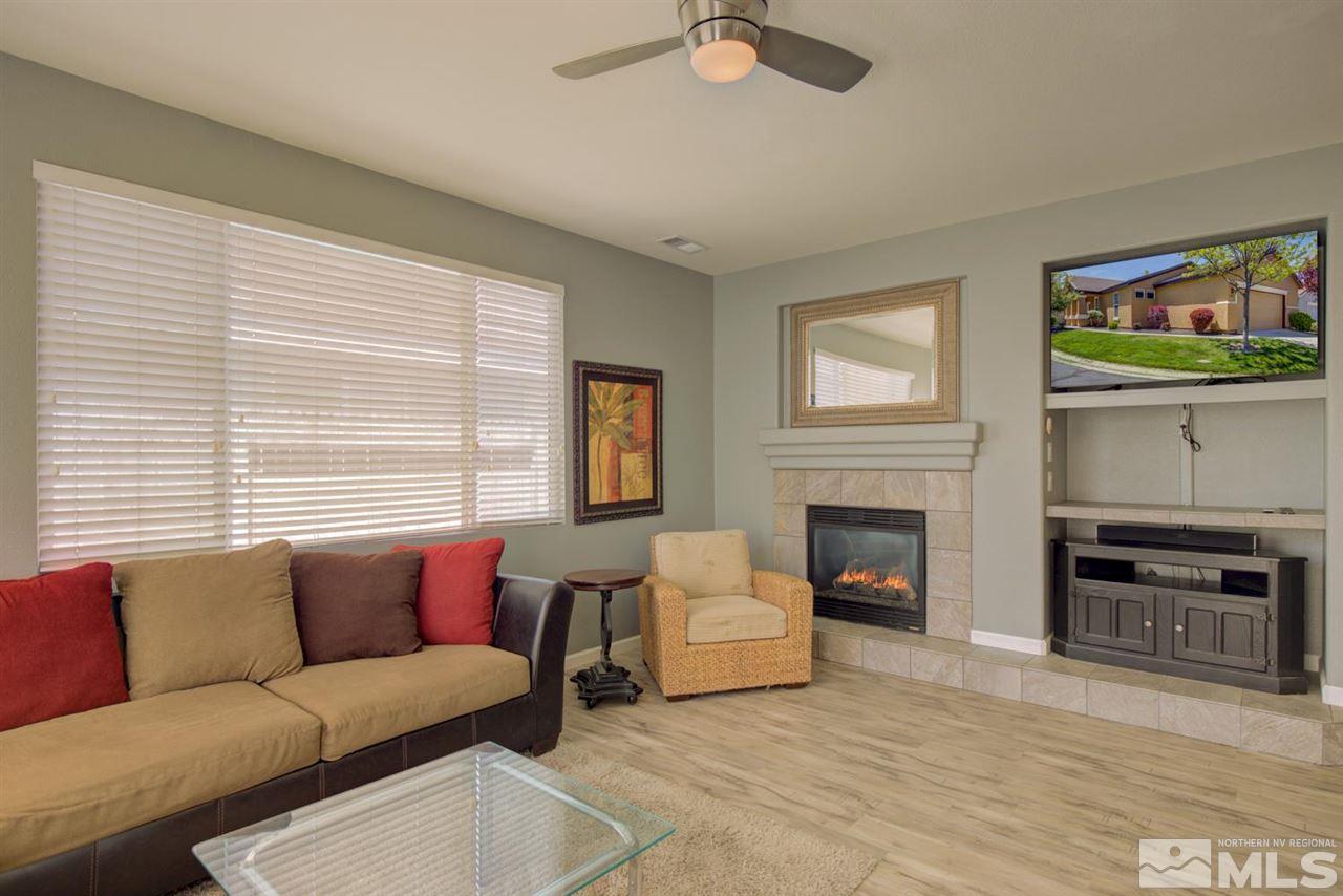 10482 Gold Trail Drive Reno, NV 89521 - Photo 4 of 40 a living room with furniture a flat screen tv and a fireplace