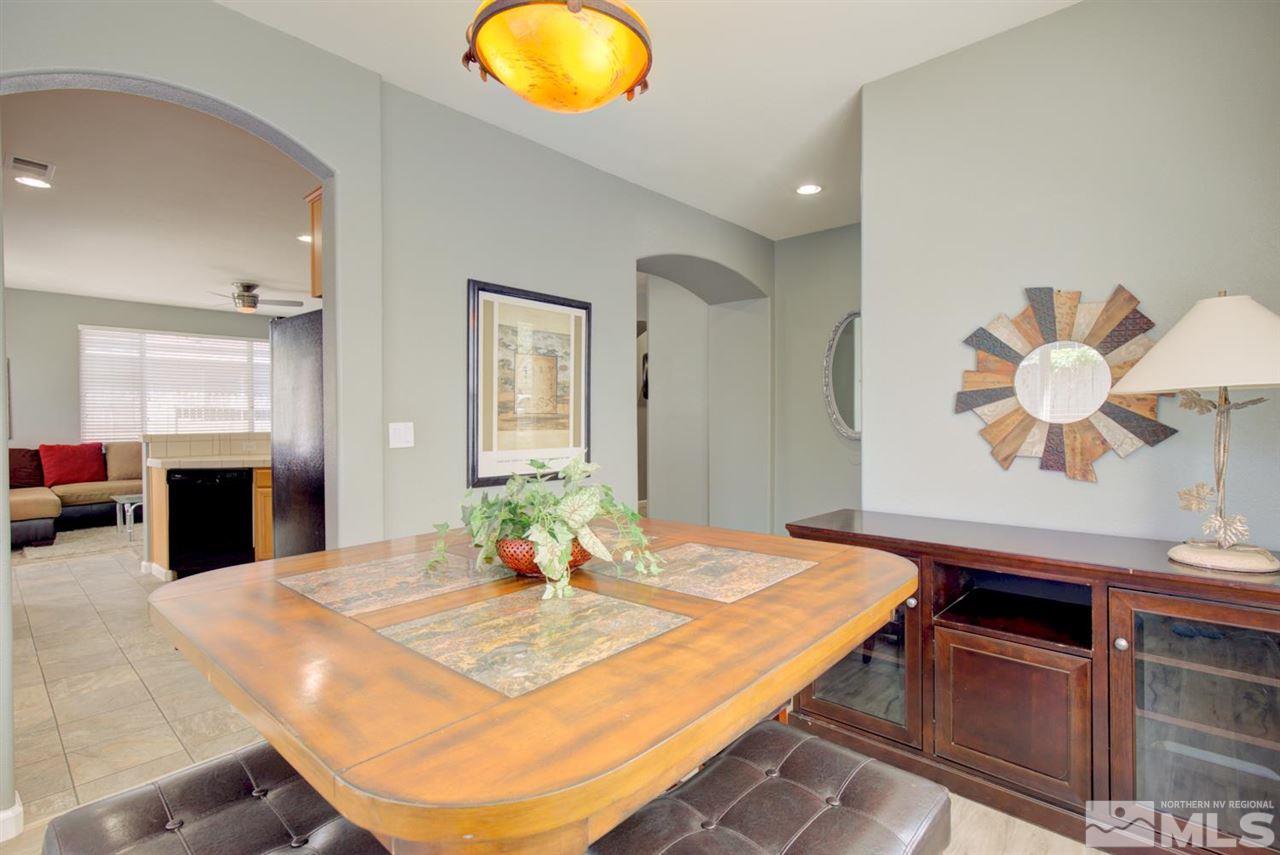 10482 Gold Trail Drive Reno, NV 89521 - Photo 6 of 40 a kitchen with stainless steel appliances kitchen island granite countertop a table and chairs in it